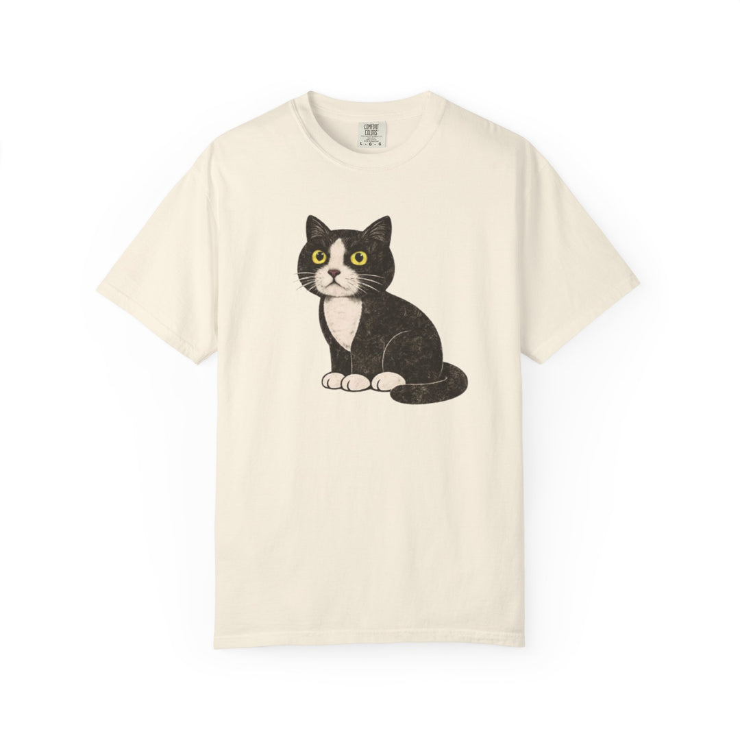Beige t-shirt with a black and white cat graphic on a white background